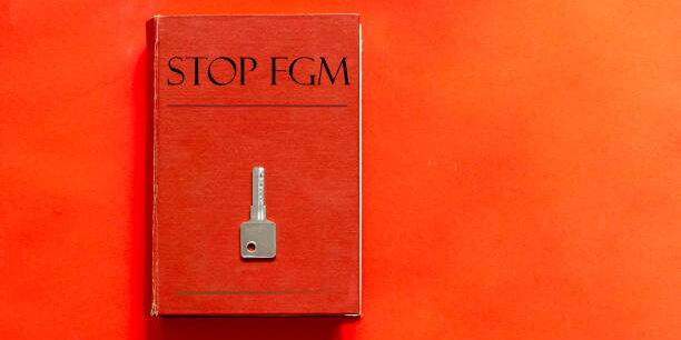 red book with text Stop Fgm and a key on a red background
